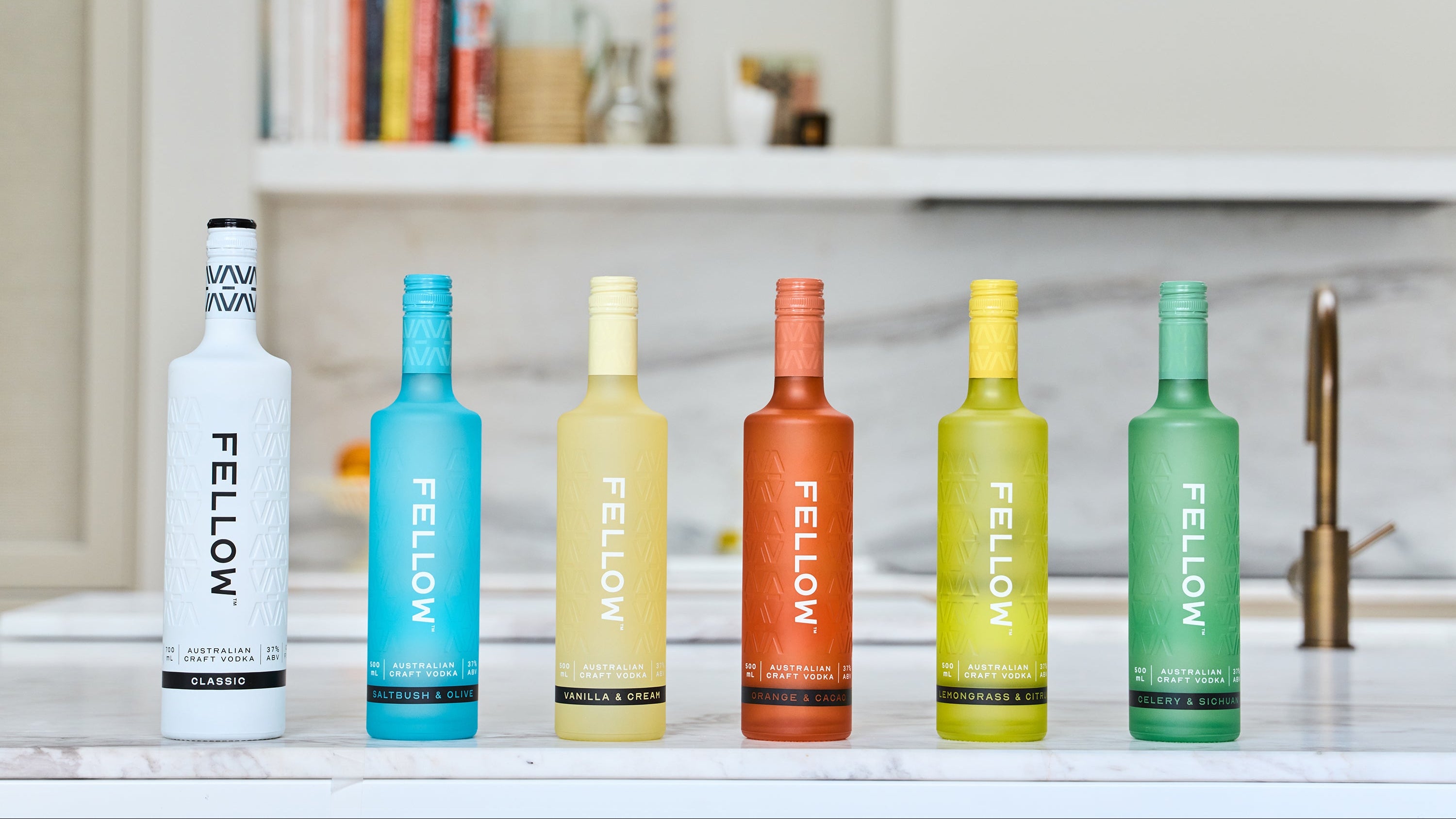 Set of colorful 'Fellow' bottles on a kitchen counter.